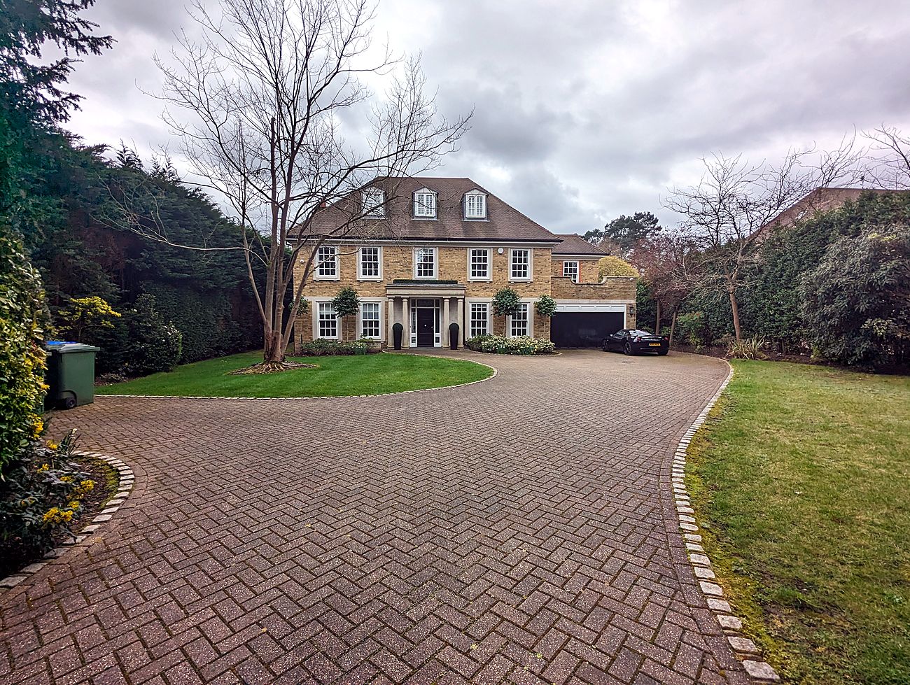 A large detached private residence with a block-paved drive on the Burwood Park Estate, Surrey