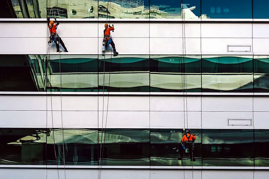 Rope-access operatives inspecting a building façade as part of planned maintenance